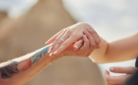 Close up of couple's hands showing wedding ring
