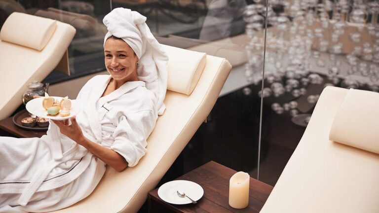 Woman in white robe sitting in a spa having a snack